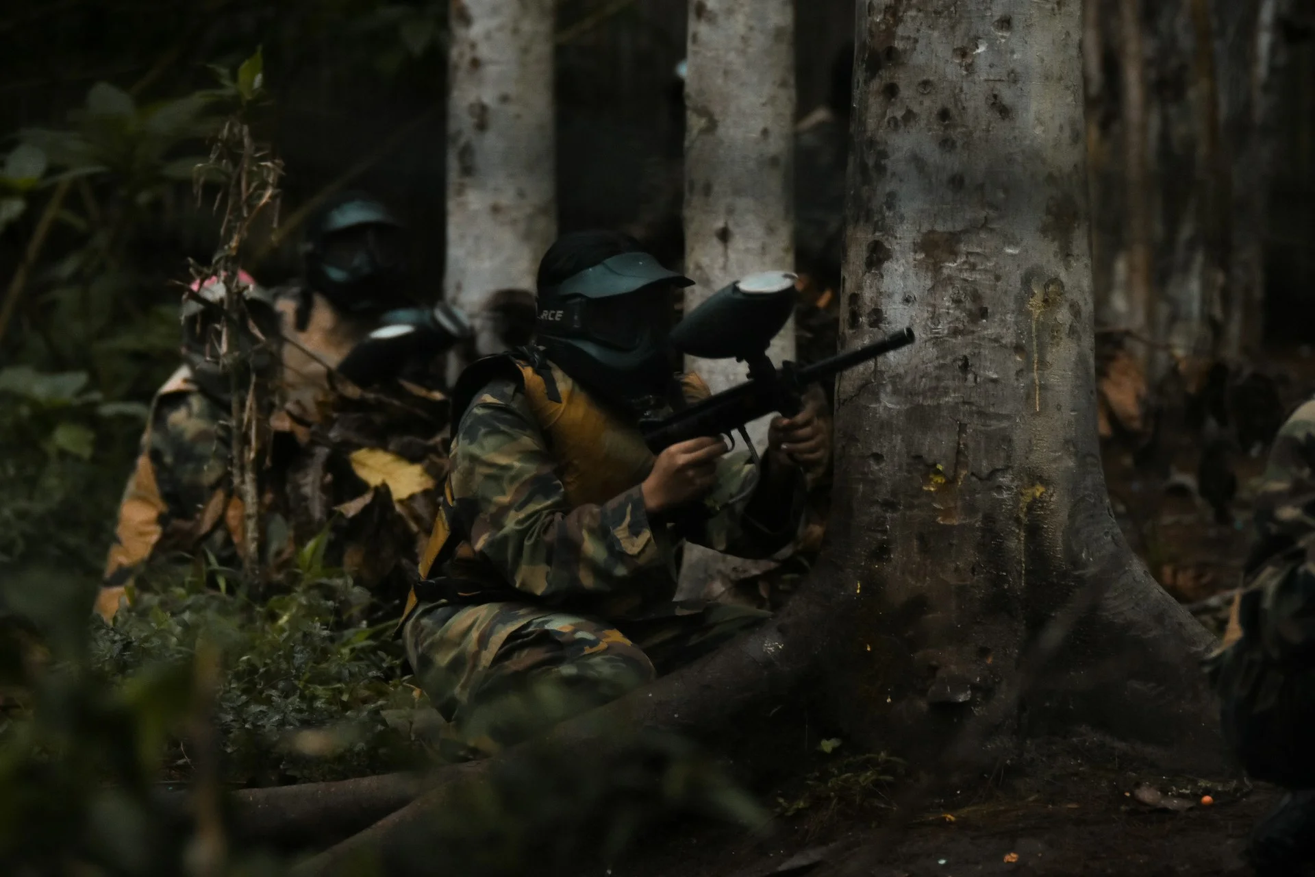 Peserta paintball mengenakan pelindung dan membawa marker