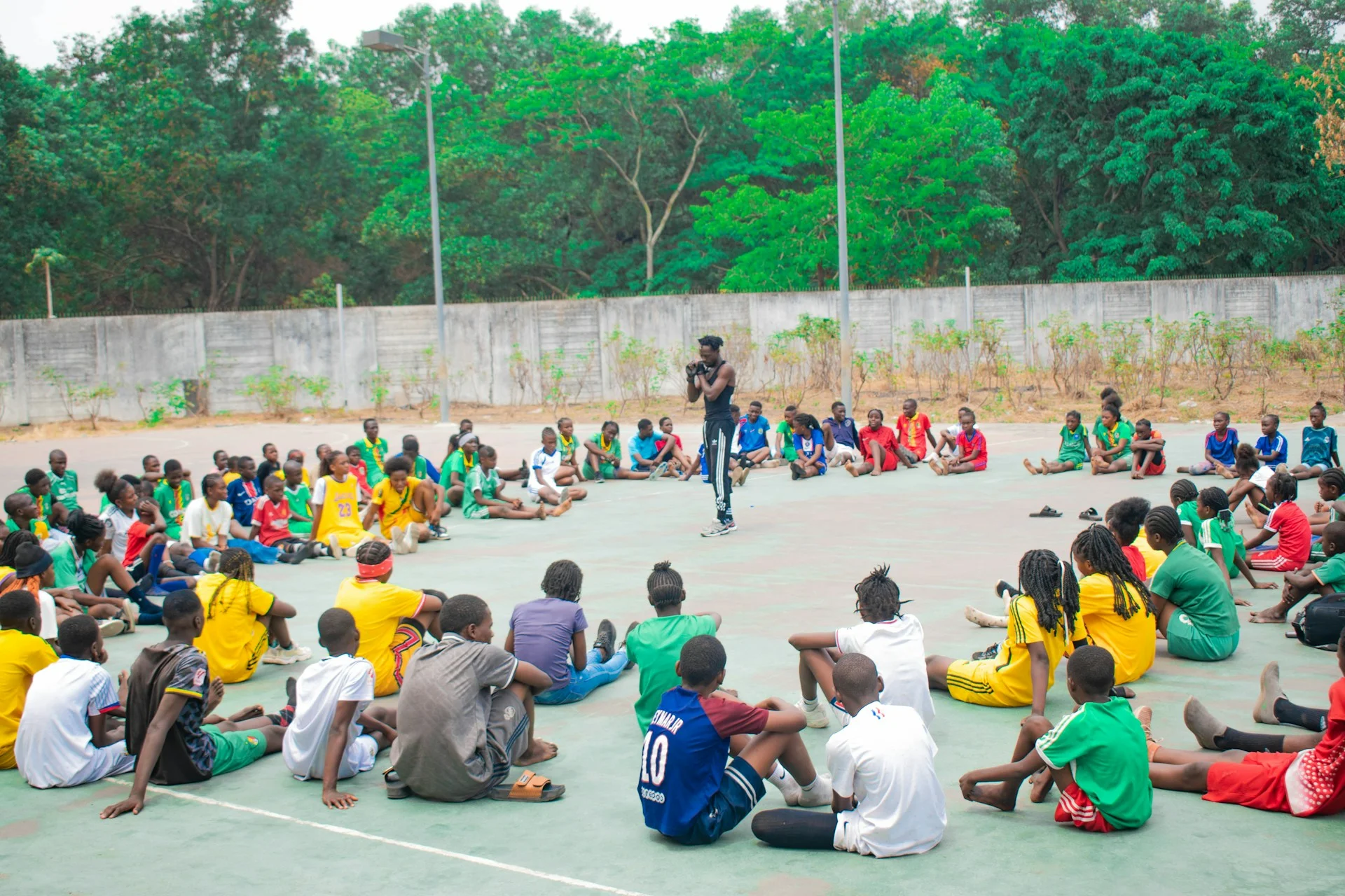 Man addresses group of people sitting in a circle