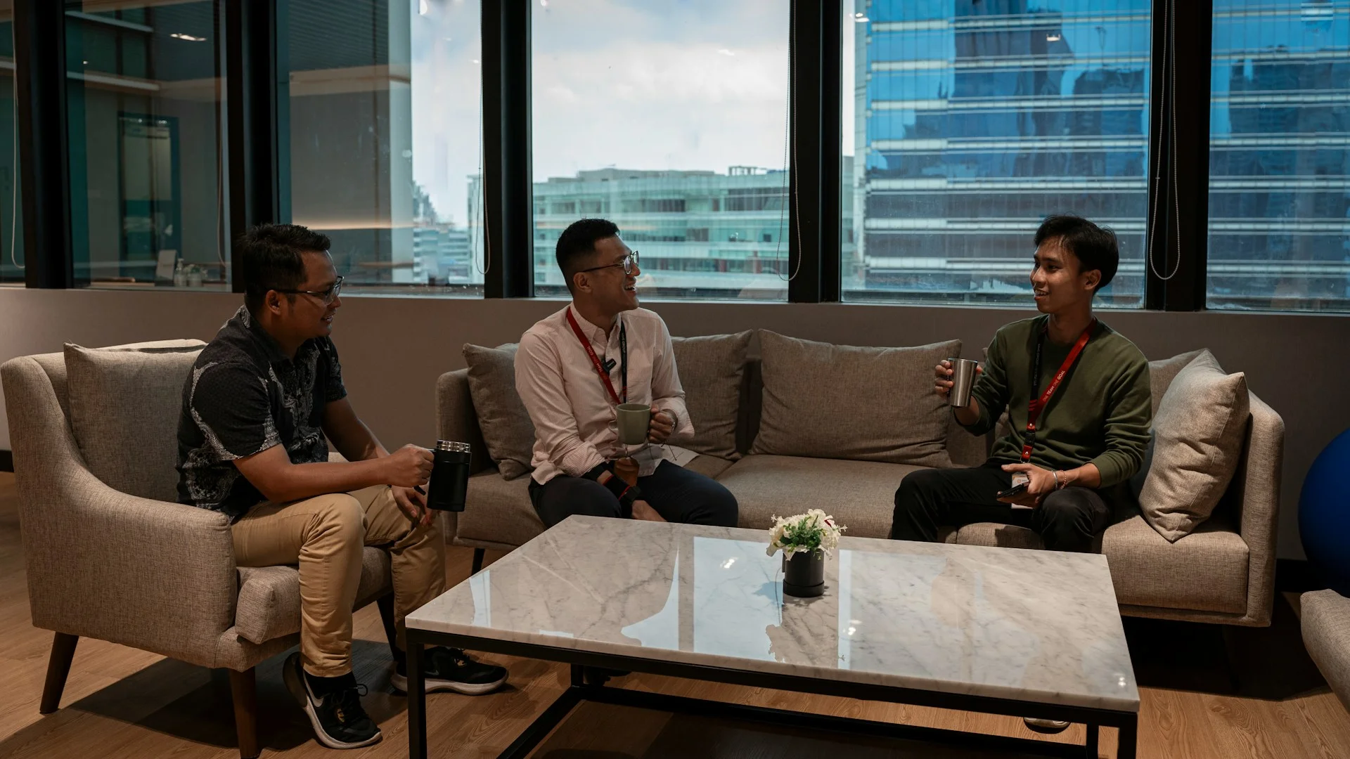 Tiga orang berbincang sambil duduk di sofa dalam sebuah ruangan di Jakarta, Indonesia