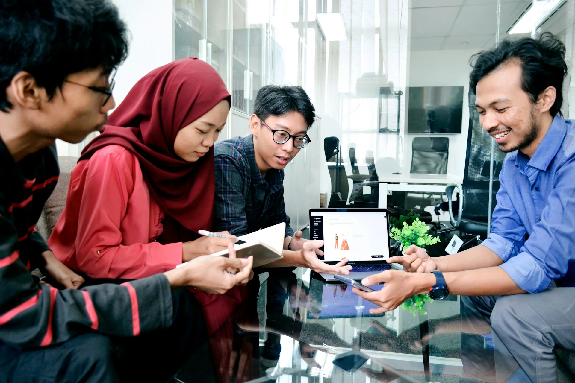 Empat peserta berdiskusi sambil memegang catatan di Jakarta, Indonesia