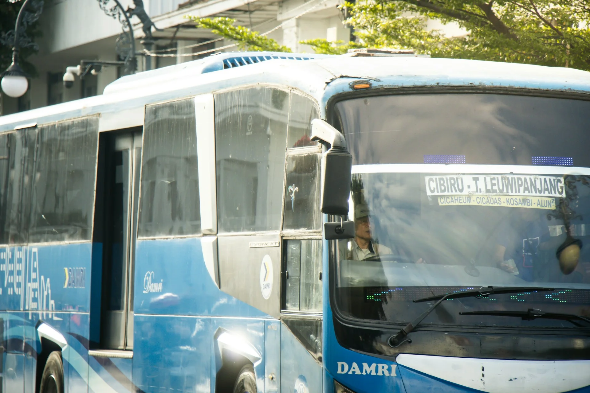 Bus berwarna biru berada di jalanan Bandung, Jawa Barat, Indonesia